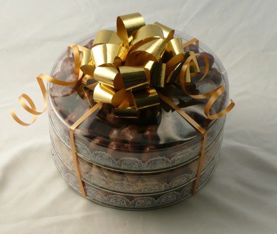 Three Tier Rounds | Nut Mixes - Round containers containing pecan halves, natural pistachios in the shell, and large whole cashews that are all tied together with a large bow.